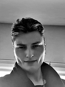 a black and white photo of a man with a necklace that says ' abercrombie & fitch ' on it