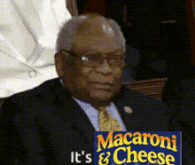 a man in a suit and tie holding a sign that says macaroni and cheese