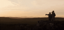 a couple standing on top of a hill looking at the mountains
