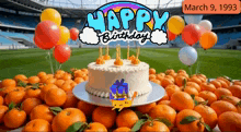 a birthday cake is surrounded by oranges and balloons and the date march 9 1993