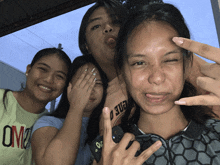 four girls posing for a picture with one wearing a shirt that says ' um2 ' on it
