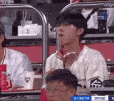 a man wearing headphones is sitting in the stands of a stadium .
