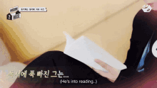 a person reading a book with the words " he 's into reading " on the bottom