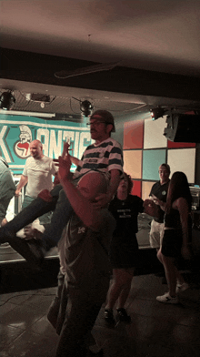 a group of people are dancing in front of a sign that says kontic