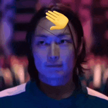 a close up of a person 's face with a hand on it .