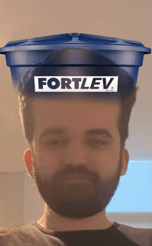a man with a beard has a blue container on his head that says fortlev on it