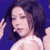 a woman with short black hair is wearing a white lace top
