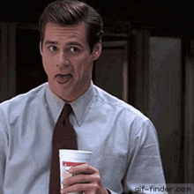 a man in a suit and tie is holding a cup that says mcdonalds on it