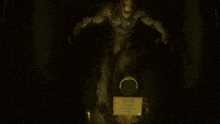 a person wearing a gas mask stands in front of a monster in a dark room
