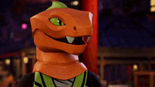 a cartoon character with an orange head and green eyes is smiling