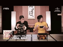 two men are eating noodles with chopsticks in a restaurant .