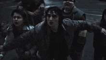 a group of children are standing in a dark room and one of them has glasses on