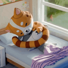 a stuffed cat is laying on a bed with a blanket
