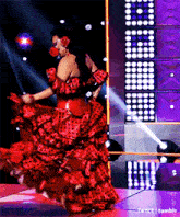 a woman in a red and black polka dot dress is dancing on a stage .