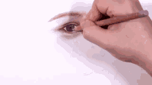 a person is drawing a woman 's eye with a pencil on a piece of paper .