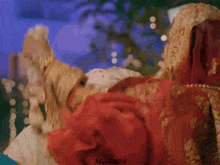 a man in a turban and a woman in a red dress are looking at each other