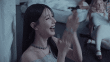 a woman in a grey top is laughing with her mouth wide open