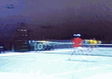 a blurred image of a tennis match with the number 8 on the wall