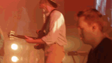 a man in a hat is playing a guitar
