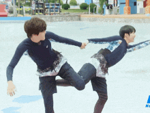 two young men are holding hands in a pool and one of them is wearing a asics shirt