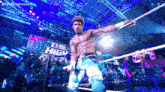 a wrestler is holding a rope in a wrestling ring while a crowd watches .