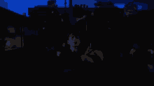 a man in a suit is sitting in a dark room with a blue light behind him