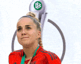 a woman wearing a red adidas shirt is standing in front of a trophy