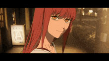 a girl with red hair is standing in front of a sign that says a