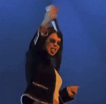 a woman is holding a microphone up in the air