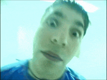 a man in a blue shirt is making a funny face in a blurry photo .