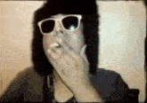 a man wearing sunglasses is smoking a cigarette