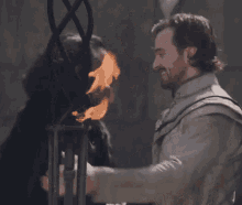 a man with a beard is hugging another man with a torch .