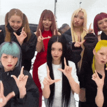 a group of girls are posing for a picture and one of them has a red dress on