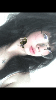 a woman wearing glasses and a necklace has a picture of a man on her face