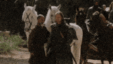 a man with a sword is standing next to a white horse