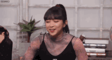 a woman wearing a black top with the word off on it is smiling .