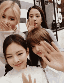 a group of young women are posing for a picture with their hands in the air