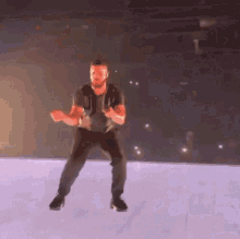 a man is dancing on a stage in front of a crowd