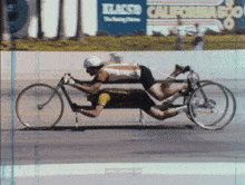 a man is riding a bicycle in front of a california 500 sign