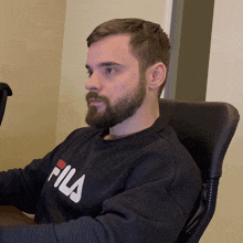 a man with a beard wearing a fila sweatshirt