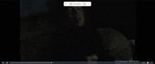 a man is laying on a bed in a dark room while playing a video .