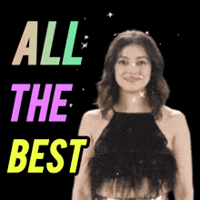 a woman in a black top is standing in front of a sign that says all the best