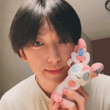 a person is holding a stuffed animal with a pink and white tail