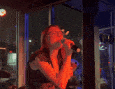 a woman singing into a microphone in front of a sign that says ' jtc ' on it