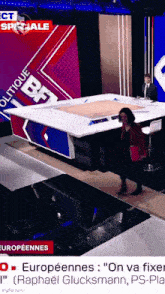 a woman is walking on a stage in front of a screen that says " ect speciale "