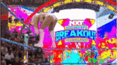 a wrestling match is taking place in front of a large screen that says nxt women 's breakout tournament .