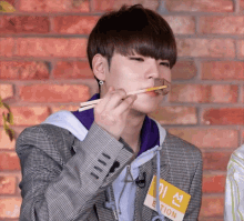 a young man wearing a name tag that says ection is eating something with chopsticks