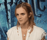 a woman in a white shirt stands in front of a poster that says harry potter