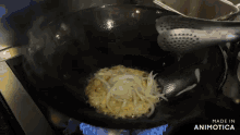 onions are being cooked in a wok on a stove with the words made in animotica visible