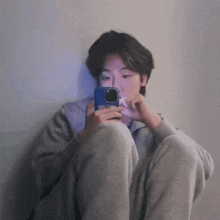 a young man is taking a picture of himself with his cell phone